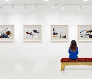 Dona mirant els quadres i obres d'art en un museu. 
