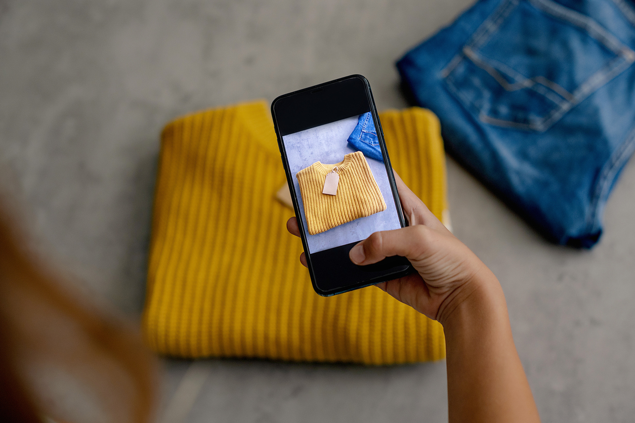 A woman taking a photo of a jumper to sell it