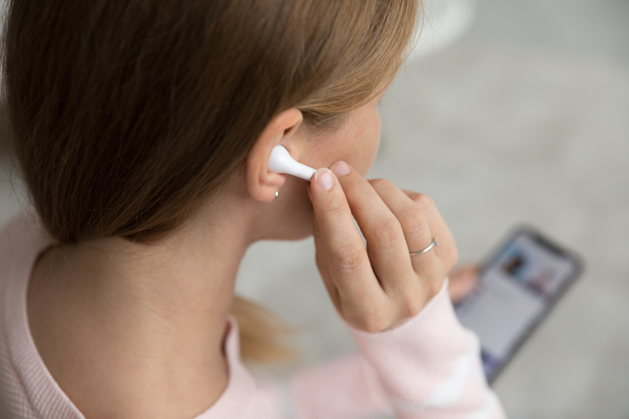 Una mujer utilizando auriculares inalámbricos