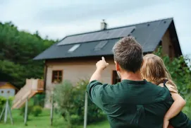 Placas solares en una casa, padre e hija las observan. 