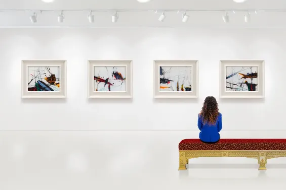 Mujer mirando obras de arte en un museo.
