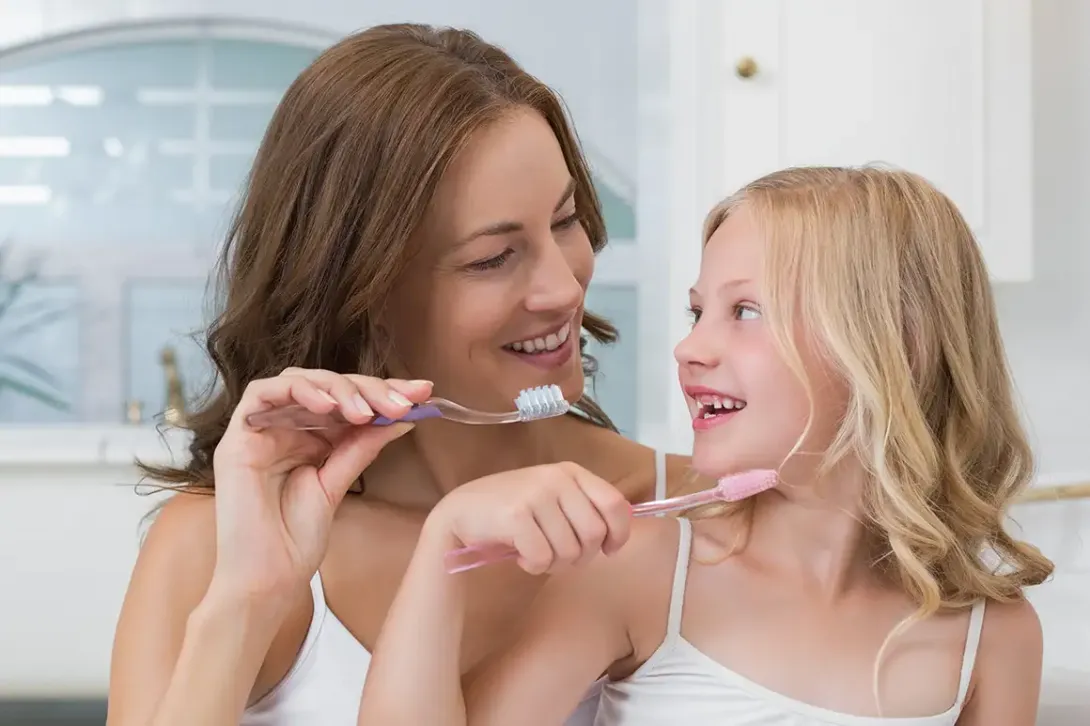 Madre e hija cepillándose los dientes