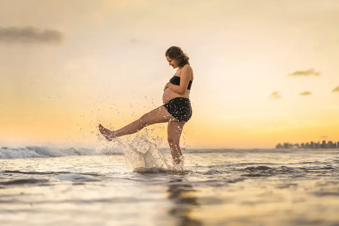 Mujer embarazada en la playa, prevención en verano.
